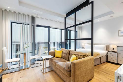 a living room with a couch and a bed at Chic Studio Living in London City Island in London