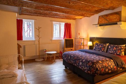 a bedroom with a bed and a table and windows at Heaven in Antwerp in Antwerp