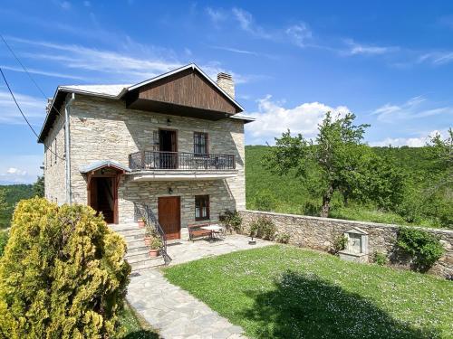 Casa de piedra grande con balcón en la parte superior. en Villa Arcturia, en Nymfaio