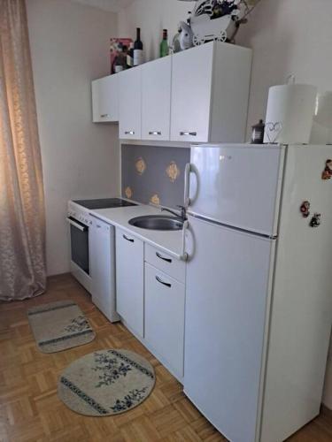 cocina con nevera blanca y fregadero en Lovely Apartment with terrace/Divan apartman sa terasom, en Novo Selo