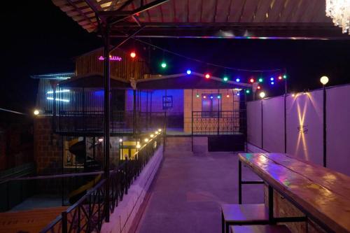 a bar with a wooden table and lights at night at Kotun: a spacious house in Gyumri in Gyumri