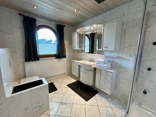 a white bathroom with a sink and a shower at 145m2Ferienwohnung Haas in Fügen