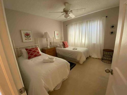 a bedroom with two beds and a ceiling fan at Harbor View, short 7 minute walk to beach. in Vero Beach