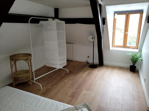 Habitación con cama, silla y ventana en Appartement atypique, en Mitry-Mory