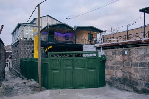 a green garage door in front of a house at Kotun: a spacious house in Gyumri in Gyumri