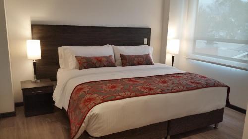 a large bed in a hotel room with two lamps at AZ Hotel in Bogotá