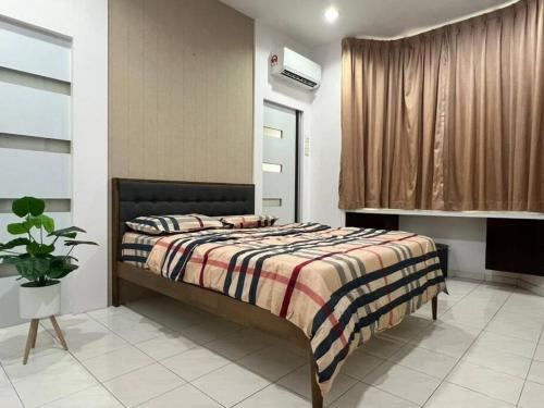 - une chambre avec un lit et une couverture rayée dans l'établissement Muar 6 Bedrooms Semi-D With Security Guard Homestay 15-20pax, à Muar