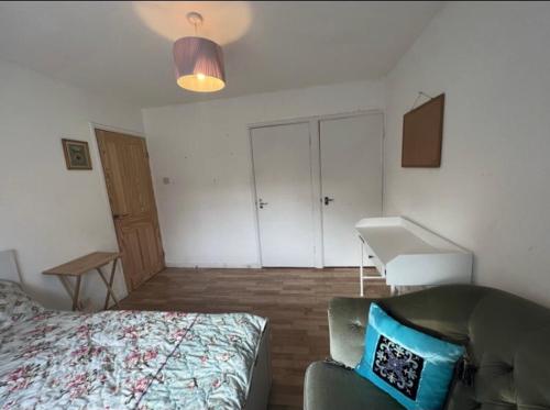 1 dormitorio con cama, escritorio y lavamanos en Spacious Large Modern Double close to Central London Breakfast Included en Londres
