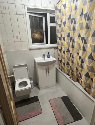 a small bathroom with a sink and a toilet at Spacious Large Modern Double close to Central London Breakfast Included in London