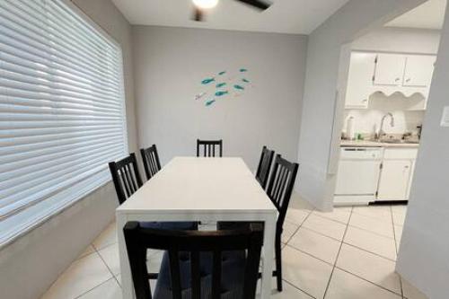 a dining room with a white table and chairs at 2 Bedroom Beach Condo With Dock AND Walk To Everything in St Pete Beach