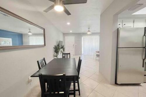 a dining room with a black table and a refrigerator at Beautiful Madeira Beach 1 Bed Condo With Boat Dock in St. Pete Beach
