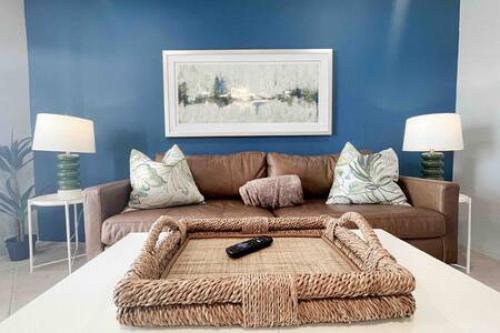ein Wohnzimmer mit einem braunen Sofa und blauen Wänden in der Unterkunft Beautiful Madeira Beach 1 Bed Condo With Boat Dock in St Pete Beach