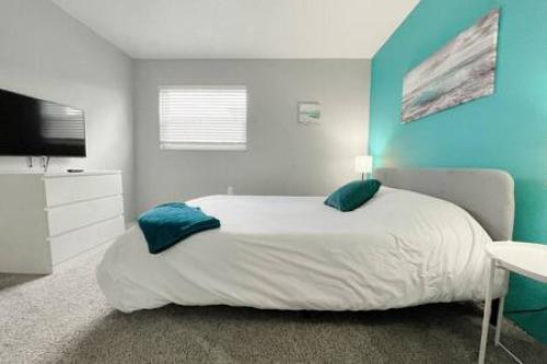 a bedroom with a large white bed with blue walls at Madeira Beach 2 bedroom Waterfront Condo With Dock in St. Pete Beach
