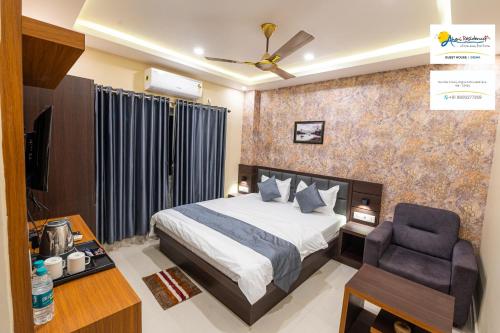 um quarto com uma cama e uma cadeira em Aheri Residency em Digha
