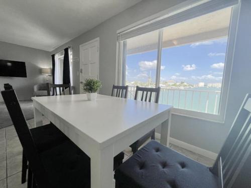 a white dining room table with a view of the ocean at Beautiful 2 Bed Beach Condo With DOCK - Walk Everywhere! in St. Pete Beach