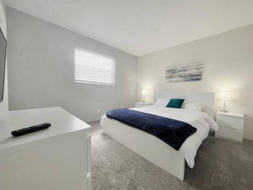 a white bedroom with a large bed and a window at Beautiful 2 Bed Beach Condo With DOCK - Walk Everywhere! in St. Pete Beach