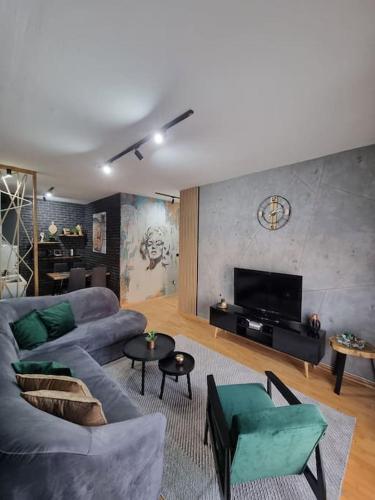 ein Wohnzimmer mit einem Sofa und einem TV in der Unterkunft Marilyn Lux Apartment in Skopje