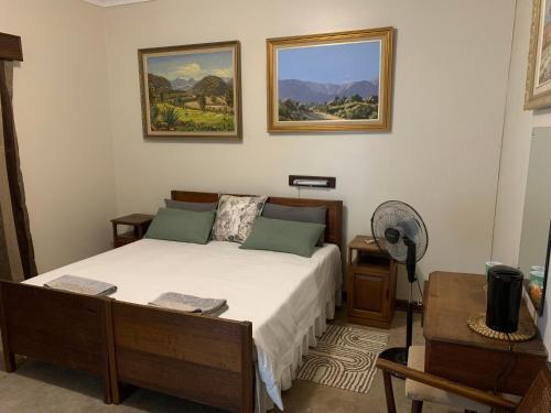 Schlafzimmer mit einem Bett und einem Ventilator in der Unterkunft Hotel De Rust in De Rust