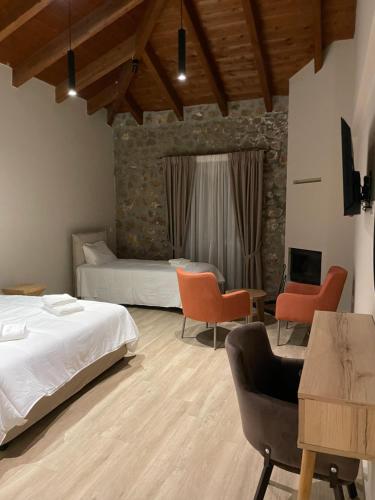 een slaapkamer met 2 bedden en een bureau met stoelen bij Miltilon in Synikia Mesi Trikalon