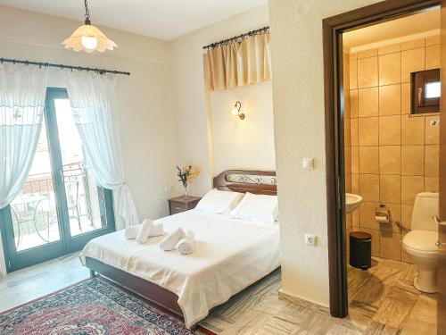 a bedroom with a bed and a bathroom with a window at Filimon GuestHouse Villa in Xanthi