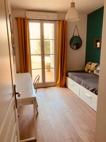 une petite chambre avec un lit et une fenêtre dans l'établissement Logement F3 moderne, un petit paradis a Paris !, au Plessis-Robinson