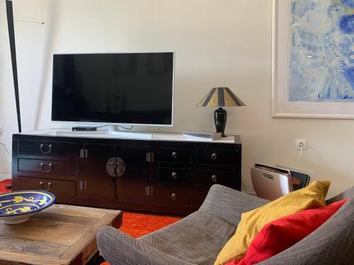 Gemütliches Appartement in Ano Poli في سلانيك: غرفة معيشة مع تلفزيون بشاشة مسطحة على خزانة