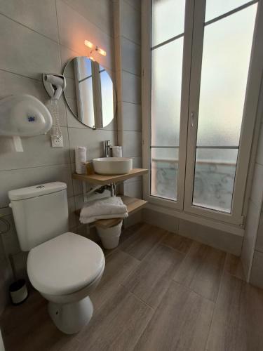 une salle de bain avec toilettes, lavabo et miroir dans l'établissement Hôtel Amaryllis, à Nice
