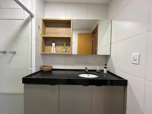 a bathroom with a sink and a mirror at Makia Flat Muro Alto in Porto De Galinhas