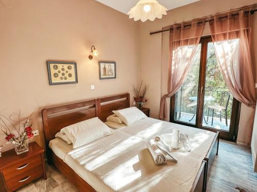 a bedroom with a bed with a table and a window at Filimon GuestHouse Villa in Xanthi