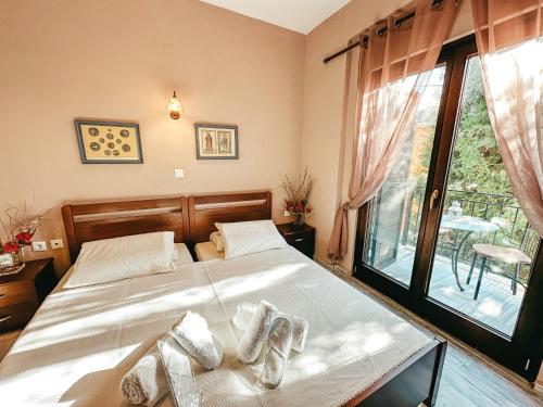 1 dormitorio con 1 cama con sábanas blancas y ventana en Filimon GuestHouse Villa, en Xanthi