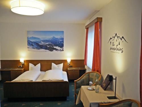 ゼーフェルト・イン・チロルにあるHotel Egerthofのベッドとテーブルが備わるホテルルームです。