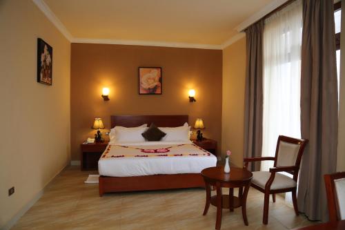 um quarto com uma cama, uma mesa e uma cadeira em Ye Afoli International Hotel em Addis Ababa