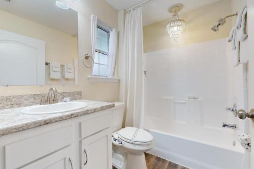 La salle de bains blanche est pourvue d'un lavabo et de toilettes. dans l'établissement The Golden Hideaway, à Saint Augustine