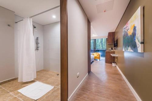 a room with a hallway with a shower and a bathroom at El Tesoro Medellín Hab315 by Letoh in Medellín