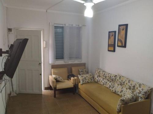 a living room with a couch and a tv at Canto do Forte Apto térreo in Praia Grande