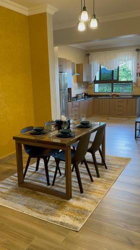 a dining room table with chairs and a kitchen at Westwood Residences in Arusha