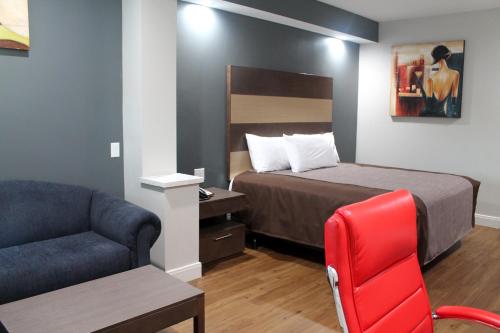 um quarto de hotel com uma cama e uma cadeira em Grand Villa Inn and Suites Westchase/Chinatown em Houston