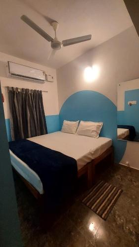 a bedroom with a bed with a blue wall at OceanBliss_Homestay04 in Villupuram