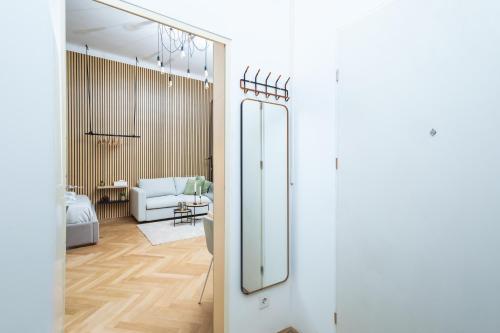 einen Flur mit Spiegel und ein Wohnzimmer in der Unterkunft Charming retreat near town centre in Wien