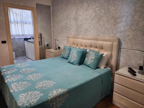 - une chambre avec un lit doté de draps bleus et une fenêtre dans l'établissement Villa Florencia, à Boca Chica