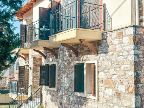 a stone building with windows and balconies on it at Filimon GuestHouse Villa in Xanthi