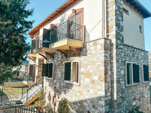 a stone house with a balcony on the side of it at Filimon GuestHouse Villa in Xanthi