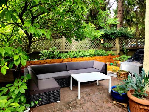 a patio with a couch and a table and plants at Small Private Studio at Kitsilano Beach in Vancouver