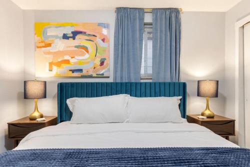 een slaapkamer met een bed met een blauw hoofdeinde en 2 lampen bij Maple Heights Haven - Unit 4 in Maple Heights