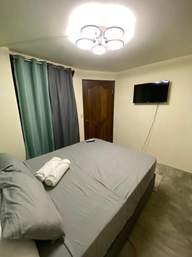 a bedroom with a bed with a ceiling fan and a television at Oasis by Franklin Hotel Boutique in Fortuna