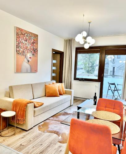 uma sala de estar com um sofá e uma mesa em Apartament przy Bulwarach em Krynica-Zdrój