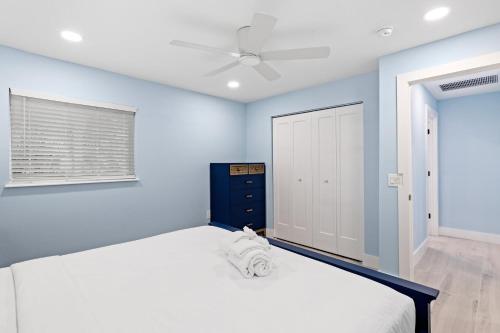 1 dormitorio con 1 cama grande y paredes azules en Caloosa Cottage at Palm View Inn of Sanibel with Bikes, en Sanibel
