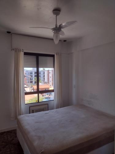 um quarto com uma cama grande e uma janela em Cobertura frente ao mar Lexus Plaza em Florianópolis