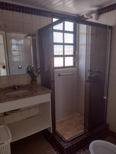 uma casa de banho com um chuveiro e um lavatório. em Cobertura frente ao mar Lexus Plaza em Florianópolis