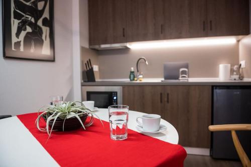Orestiada的住宿－City Kiss，一张桌子,上面有一杯水,放在红色的桌布上